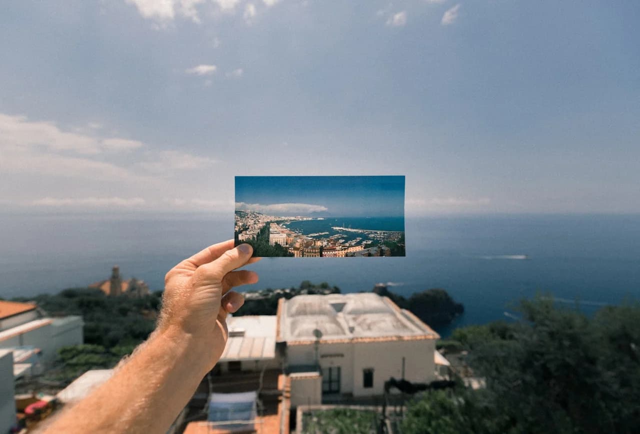 Roka, ki drži panoramsko fotografijo 15 × 30 cm vodoravno
