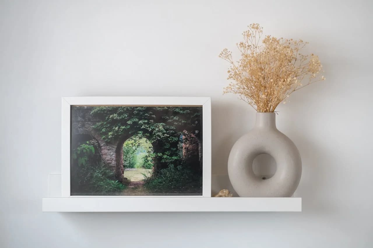 Več kvadratnih fotografij 15 × 15 cm na beli steni v simetrični mreži