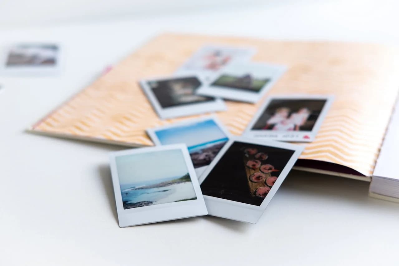 Odprt album in natisnjene fotografije na mizi