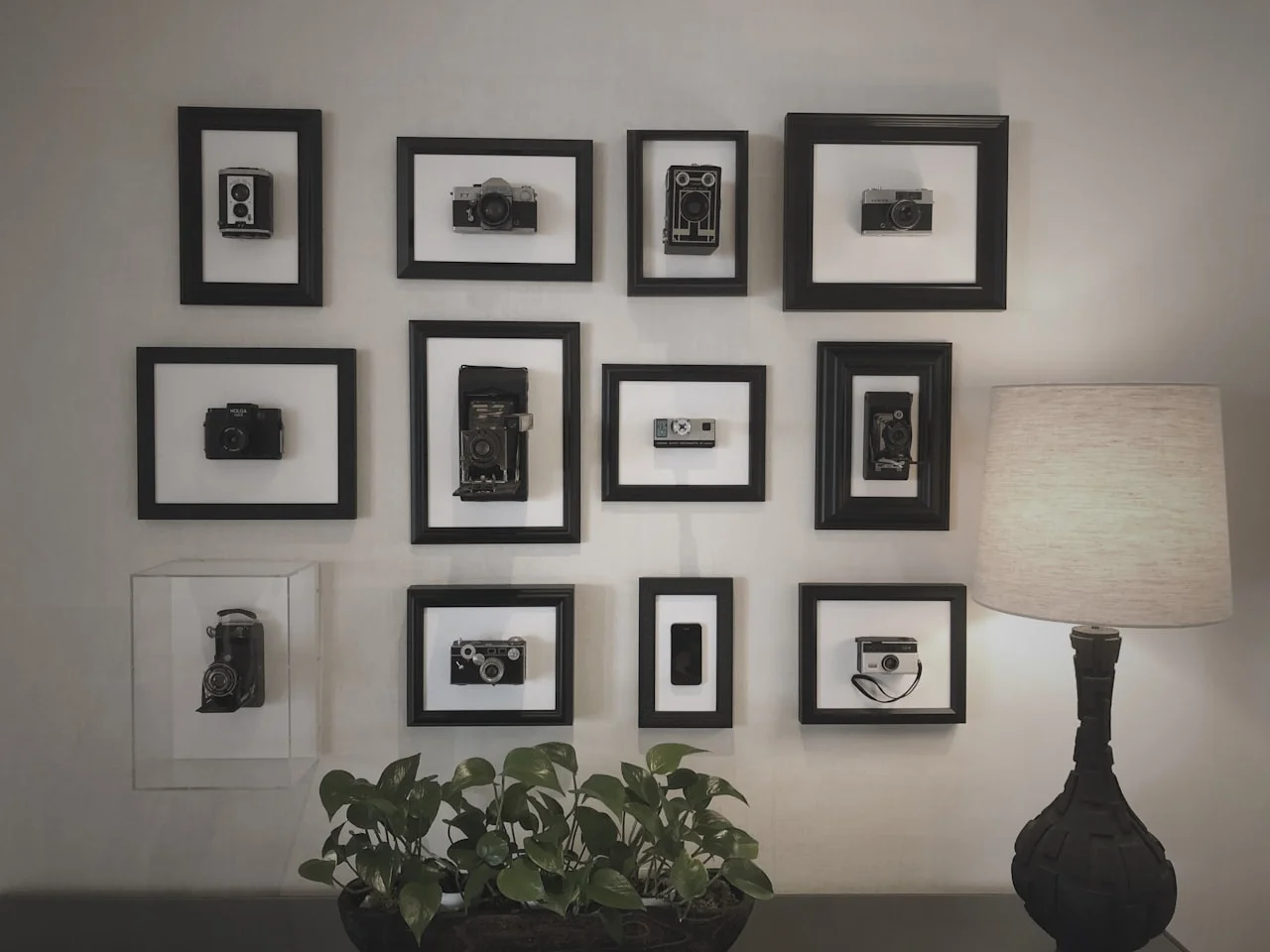 Galerijska stena z več uokvirjenimi fotografijami v simetrični postavitvi