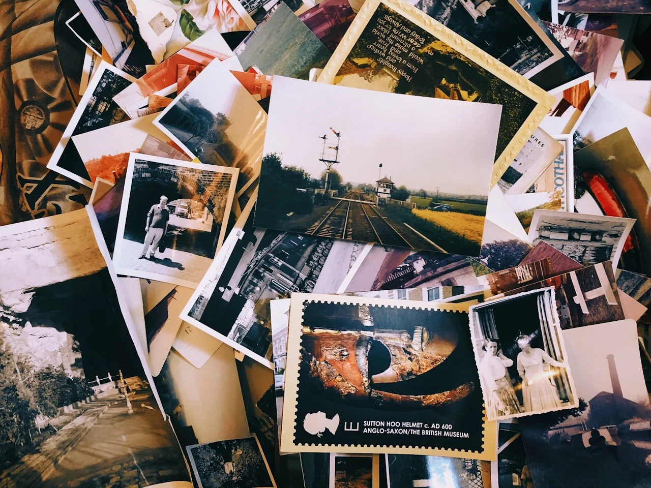 Več manjših natisnjenih fotografij razporejenih po mizi