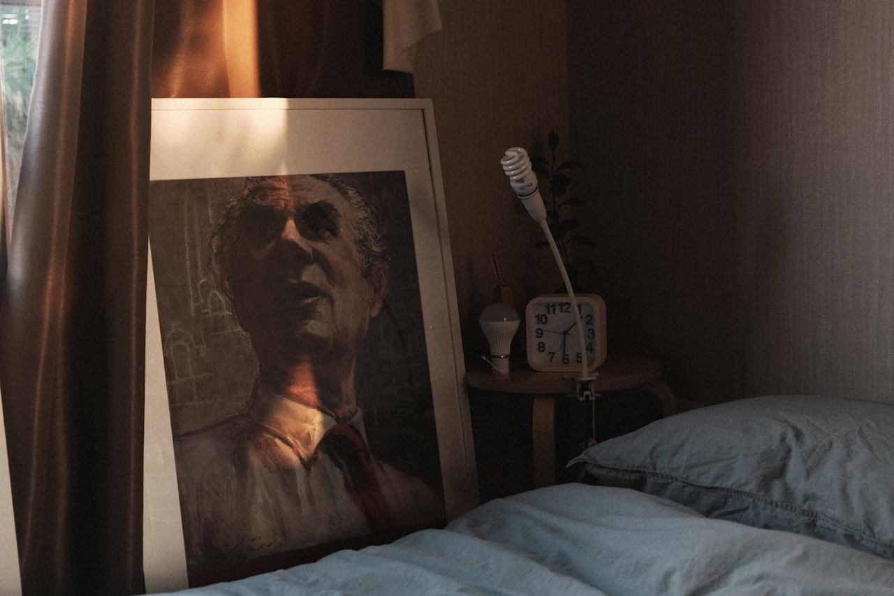 Uokvirjena fotografija ob postelji na nočni omarici