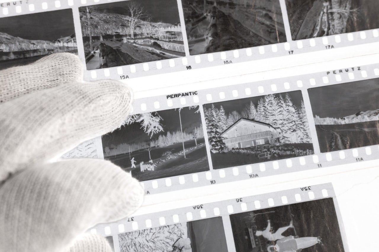 Roka v rokavicah, ki rokuje s starinskimi fotografijami