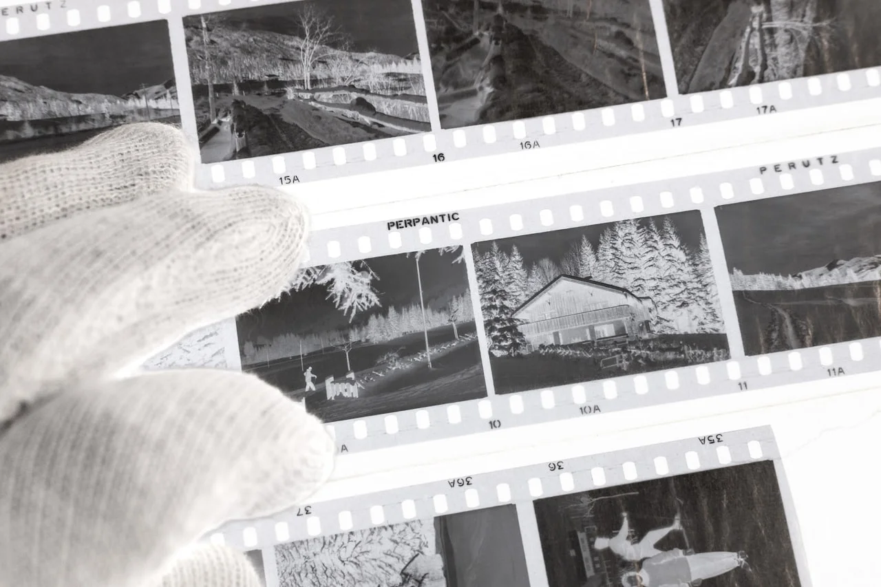 Roka v rokavicah, ki rokuje s starinskimi fotografijami