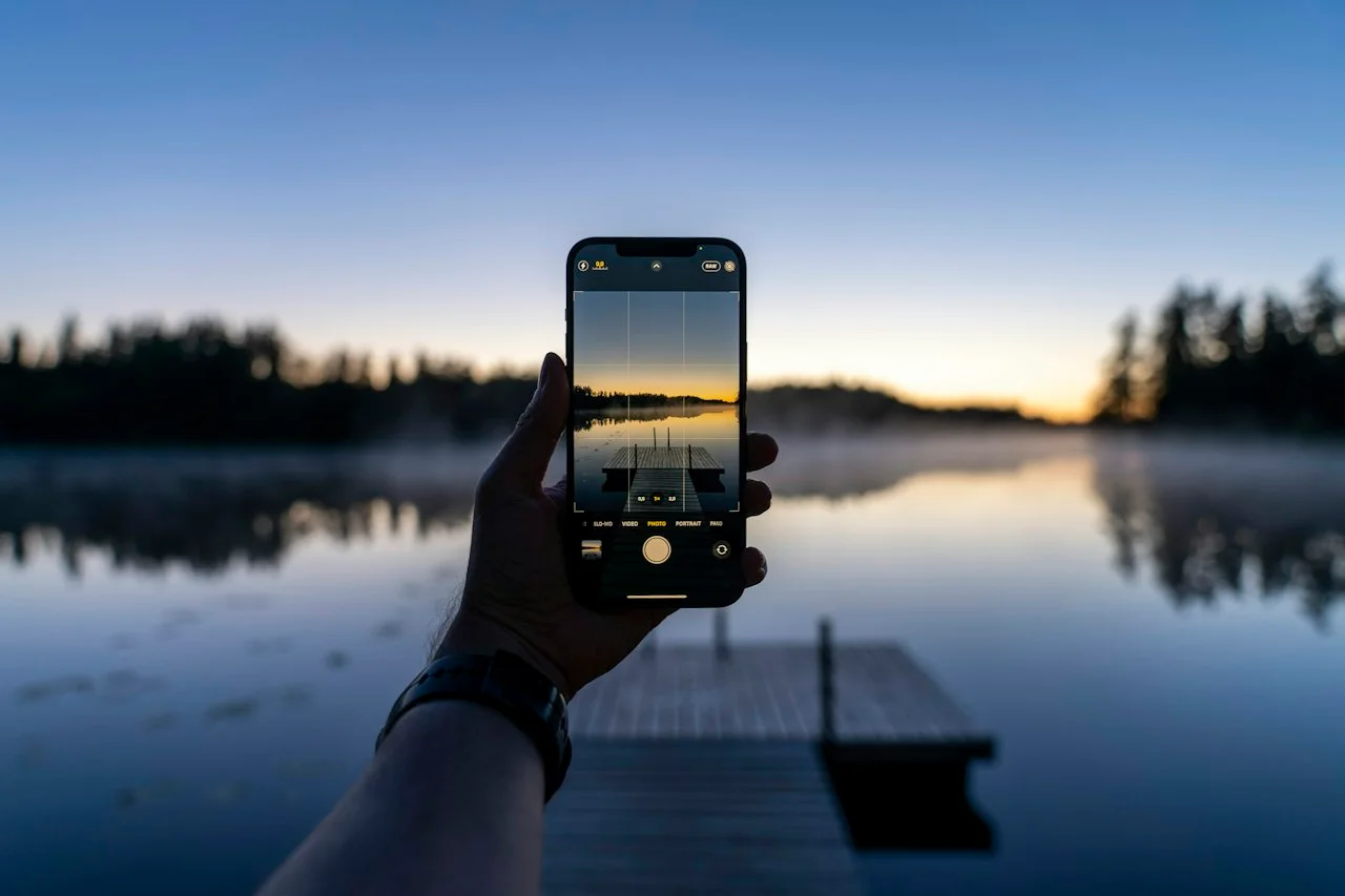 Telefon z mrežo v aplikaciji za kamero pred jezerom ob mraku