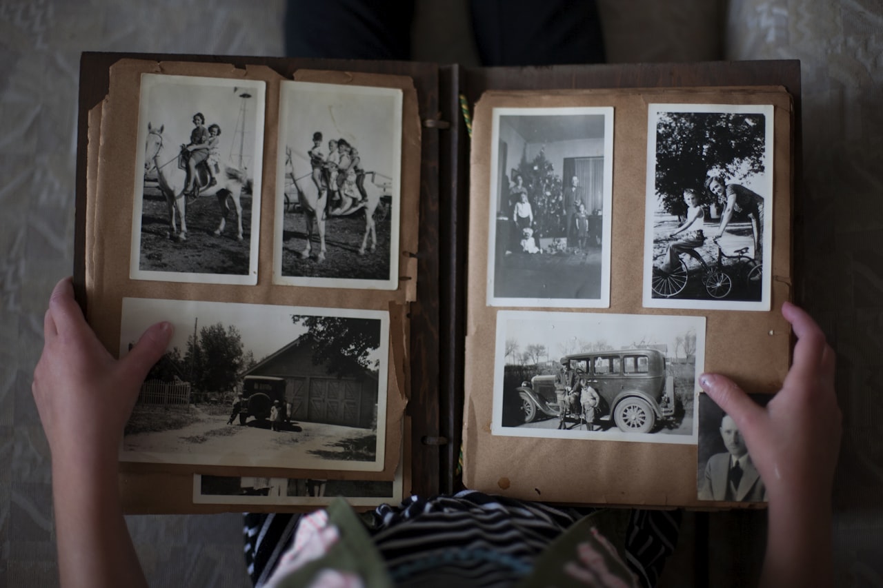 Album s fotografijami različnih velikosti odprt na mizi