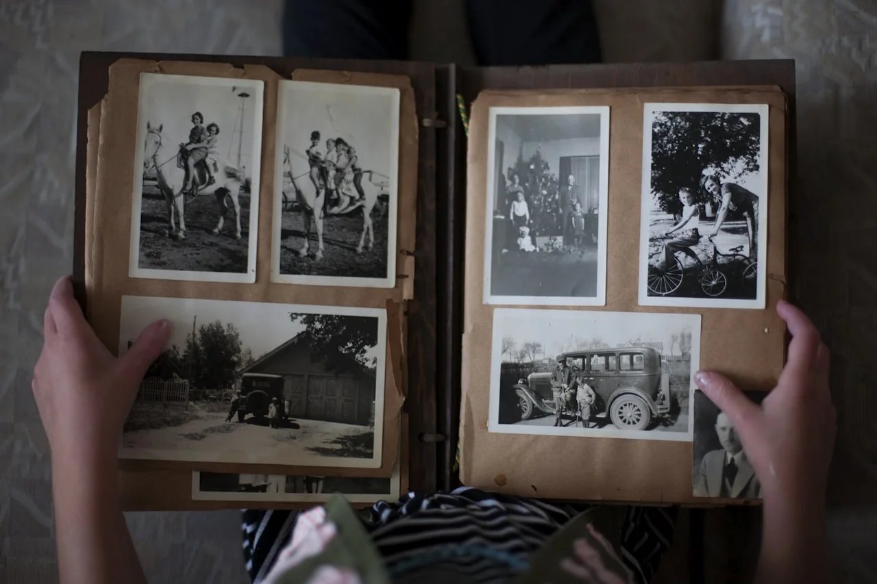 Album s fotografijami različnih velikosti odprt na mizi