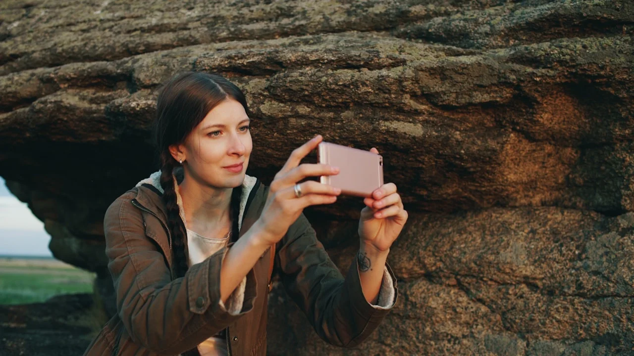 Ženska s telefonom fotografira skalnato pokrajino