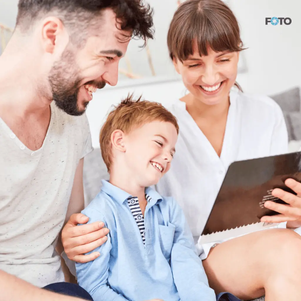 Srečna družina z otrokom gleda digitalne fotografije na tabletu