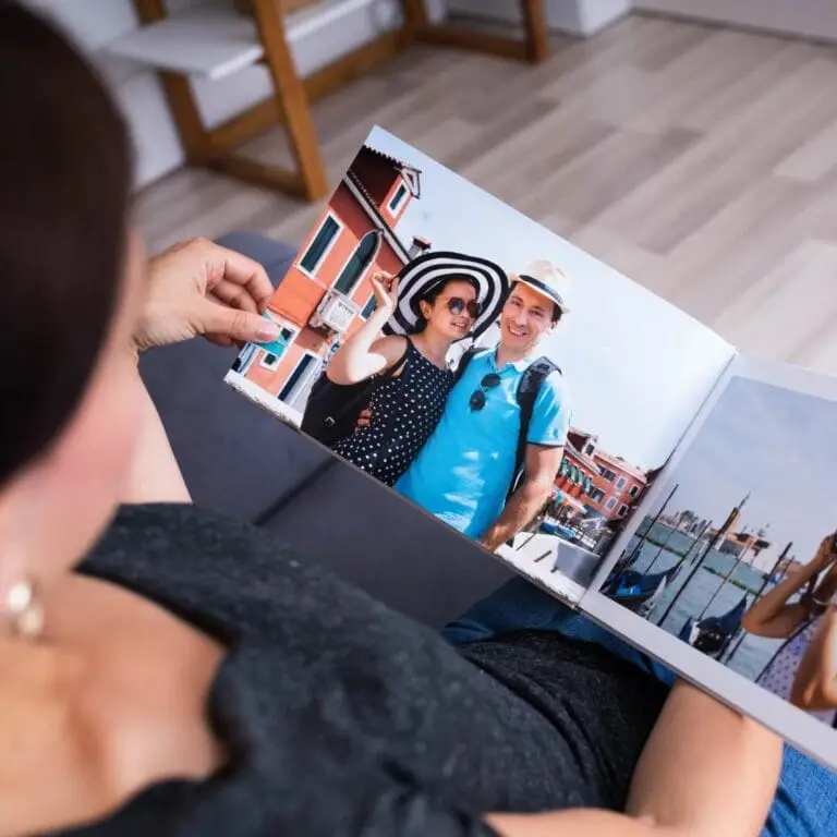 Oseba pregleduje kakovostno natiskan fotoalbum z družinskimi fotografijami"